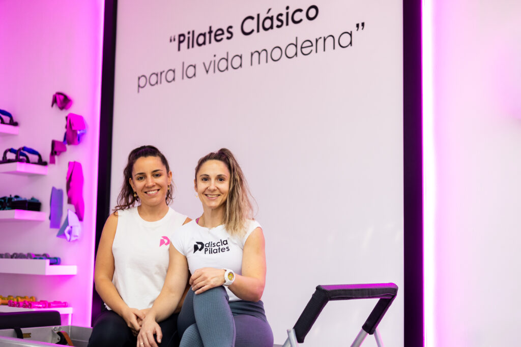 Recepción de un estudio de Pilates atendiendo a un alumno de forma cercana